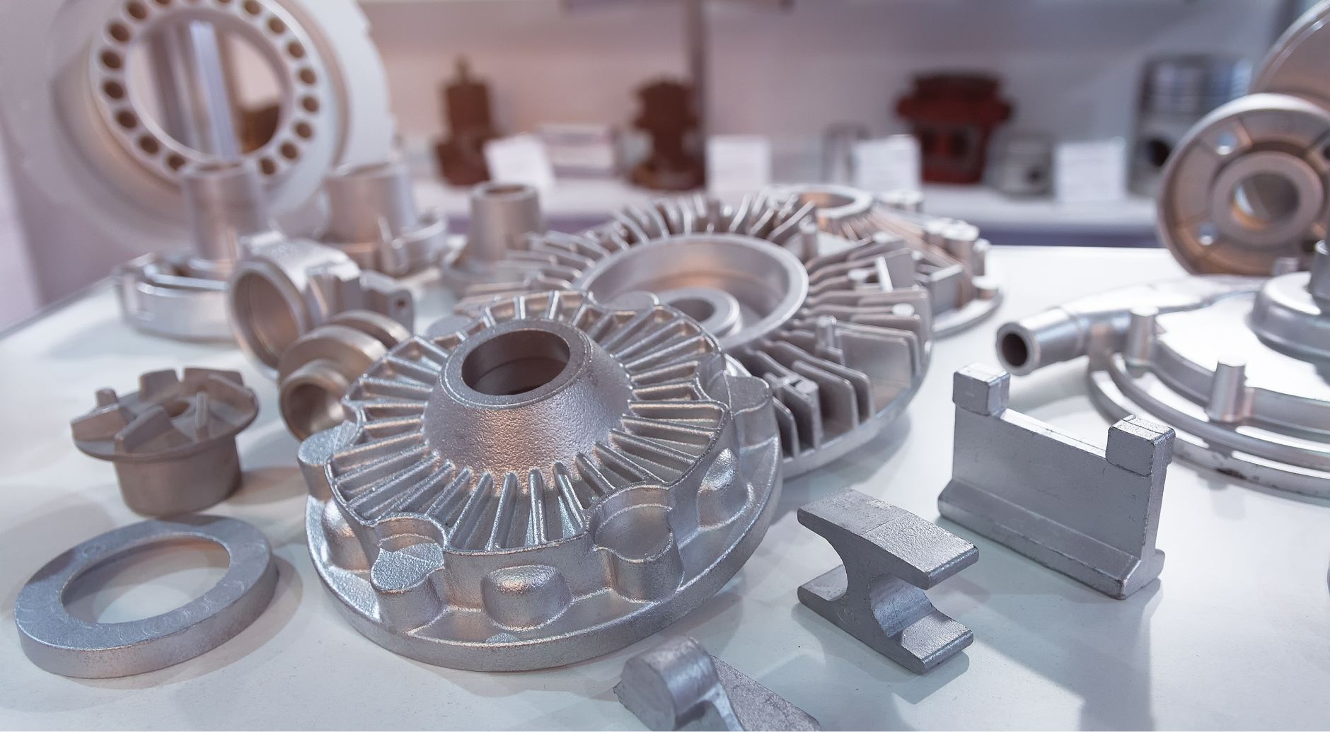Collection of precision investment cast metal components, including turbine impellers and industrial parts.