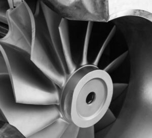 Black and white closeup of a precision investment cast turbine impeller with curved blades.